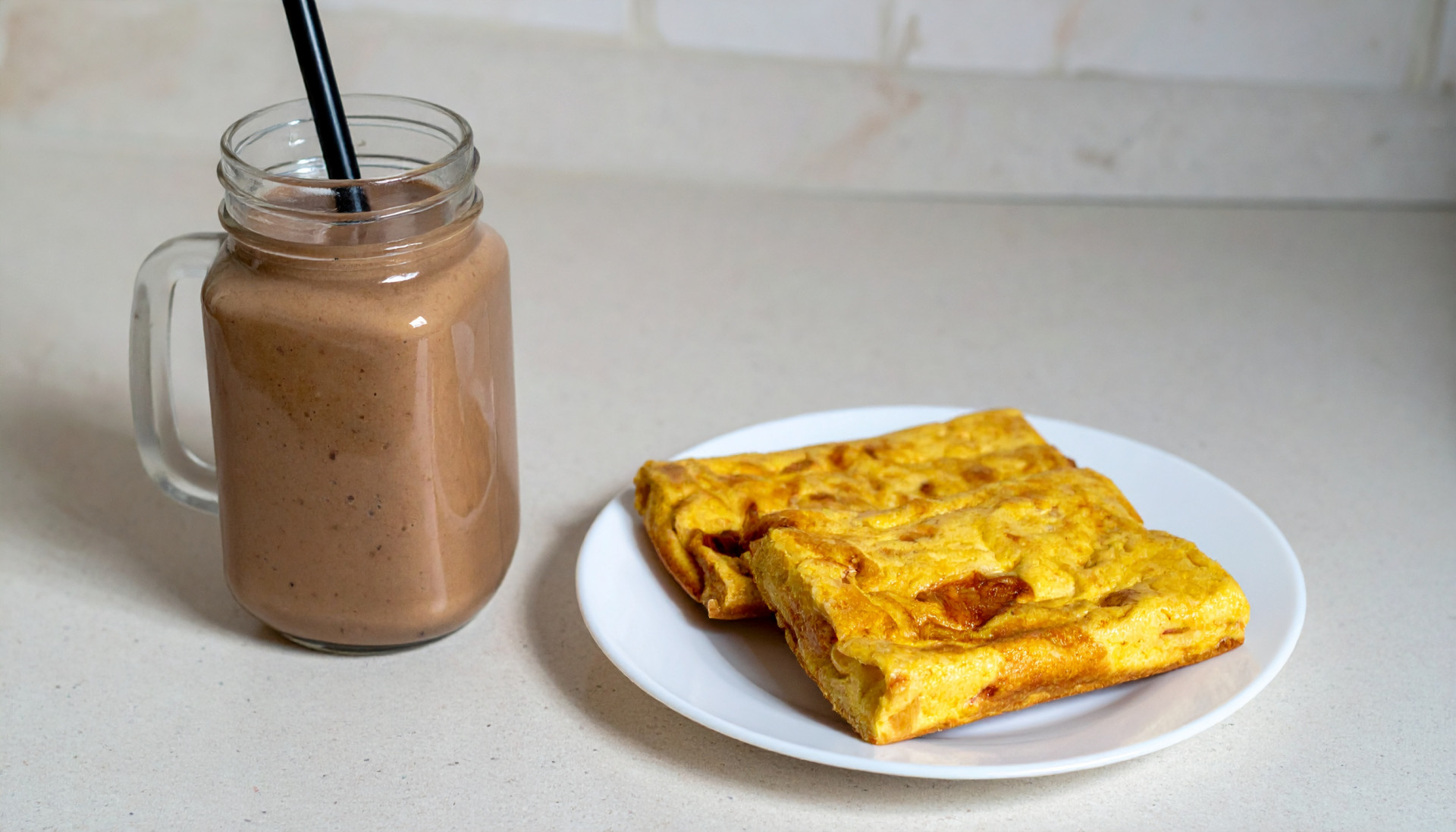 Chocolate peanut butter smoothie next to a plate of egg squares