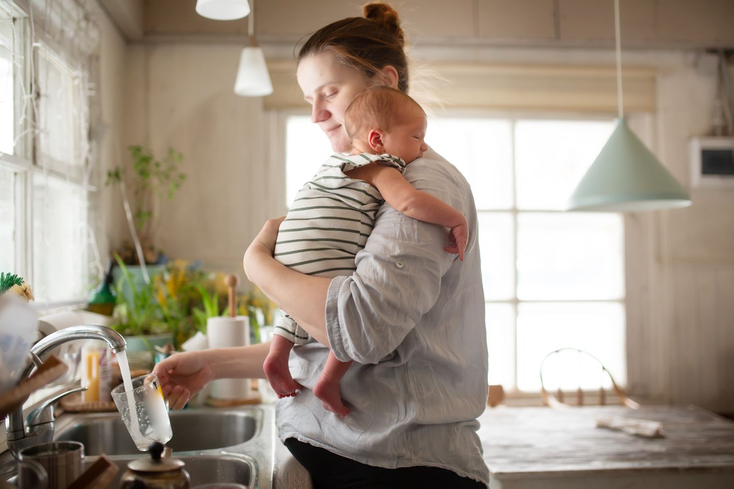 A mother holding her baby in the kitchen